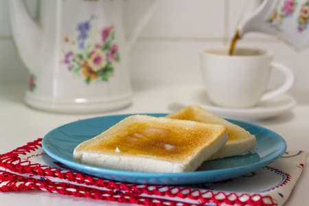 Breakfast table with butter toast and black coffeeの写真素材