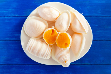 Top view of typical portuguese egg yolk sweets called Ovos Moles de Aveiro on blue wooden tableの写真素材