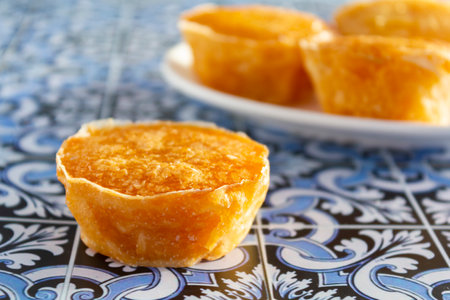 Traditional portuguese sweet bean pastry called Pastel de Feijao on portuguese tiles backgroundの写真素材