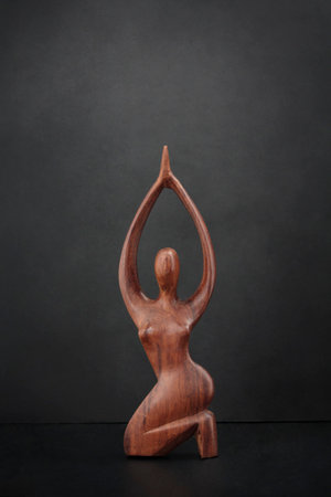 Sculpture of a woman body in wood against black backgroundの写真素材