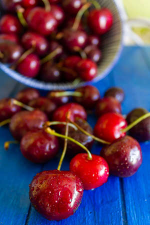 Fresh red cherries with water drops on white wooden tableの写真素材