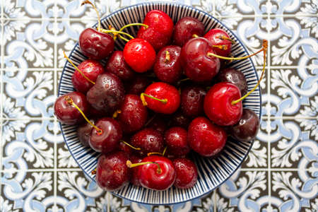 Top view of cherries bowl on portuguese tiles backgroundの写真素材