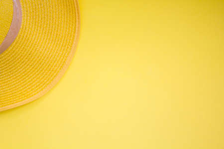 Straw summer hat on yellow background. Top view with copy spaceの写真素材