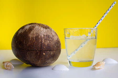 Coconut water in a glass with straw and coconutの写真素材