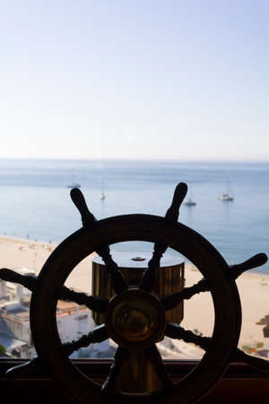 Ship's wheel with the sea on the backgroundの写真素材