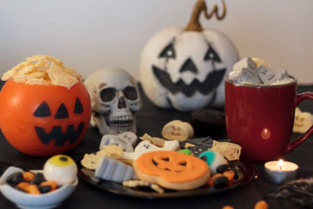 Halloween party table with treats, hot drink and snacksの写真素材