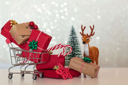 Christmas presents on shopping cart with christmas tree and reindeerの写真素材