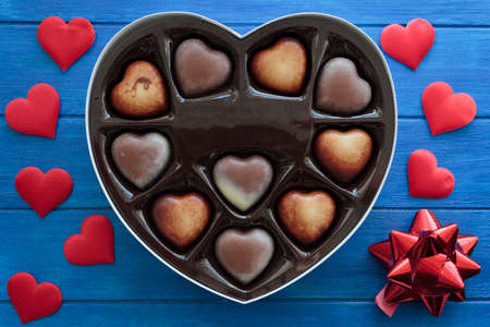 Top view of heart chocolates in gift box on blue wooden tableの写真素材