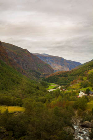 Scenic landscape of mountains, houses in valley and river. Flam in Norwayの写真素材
