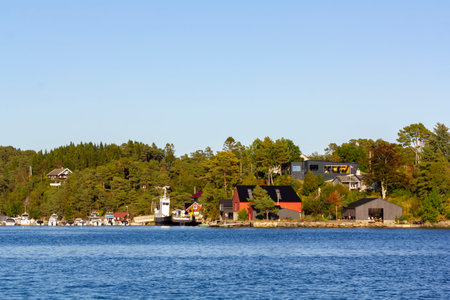 Traditional Norwegian house surrounded by trees and near the seaの写真素材