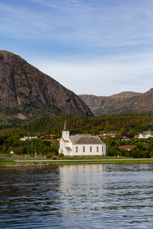 Church facing the sea in Norway, with mountains on the backgroundの写真素材