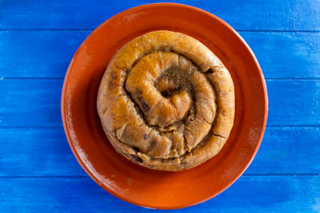 Top view of portuguese easter cake called Folar Algarvio de Olhao on blue wooden tableの写真素材