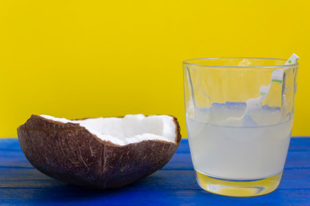 Cracked coconut and coconut water in glass with strawの写真素材