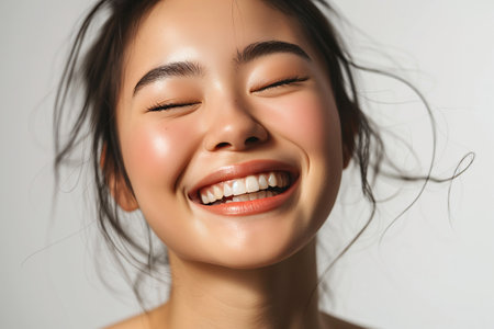 Radiant Young Woman Smiling in a Close-Up Studio Portraitの素材