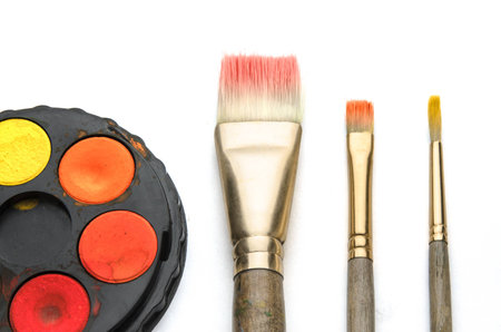 Three artist paint brushes with water colour palette isolated on white backgroundの写真素材