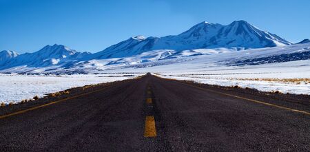 Black road in the Licancabur volcano Atacama snowy desert Chileの写真素材