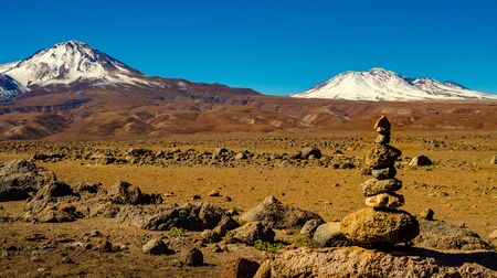 Licancabur volcano in front of vertical stones in the desert, Atacama Chileの写真素材