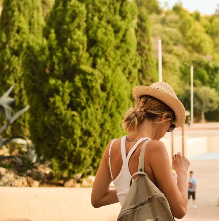 White woman with a spraw hat and sunglasses eating an ice-cream in Ibizaの写真素材