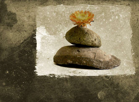 Grunge background with pebbles stack and flower - zen still life arrangementの写真素材