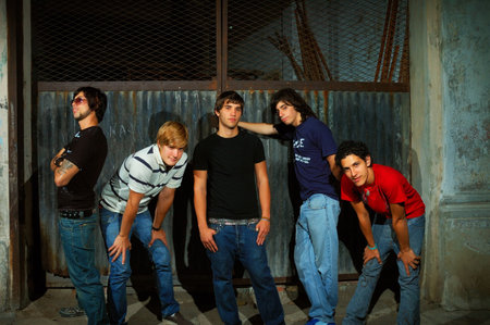 Casual group of teenagers standing against grunge wall