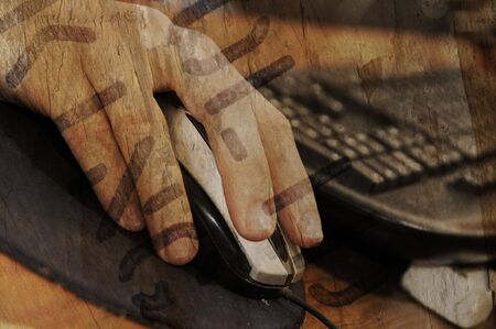 Detail of hand on mouse and keyboard over grunge backgroundの写真素材