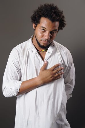 Portrait of young latin male with serious expression and hand in the chestの写真素材