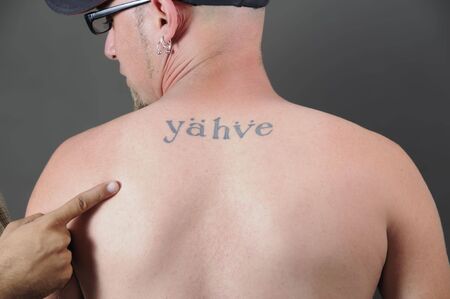 Portrait of young adult back with religious tattoo and the word の写真素材