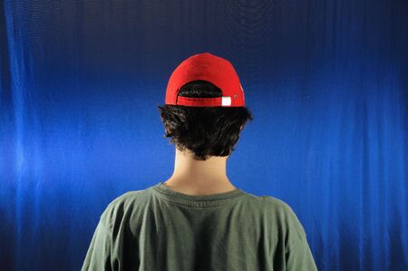 Portrait of young casual man wearing a cap - view from the backの写真素材