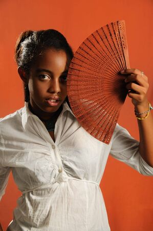 Portrait of trendy african fashion girl with fanの写真素材