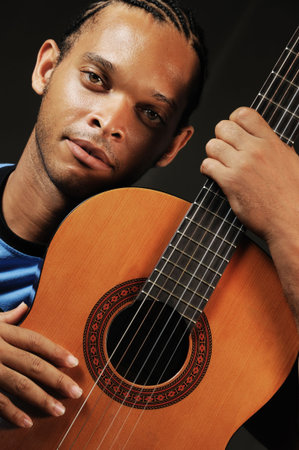 Portrait of young trendy african american man with acoustic guitar