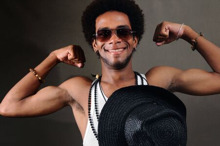 Portrait of young trendy african american man showing his musclesの写真素材