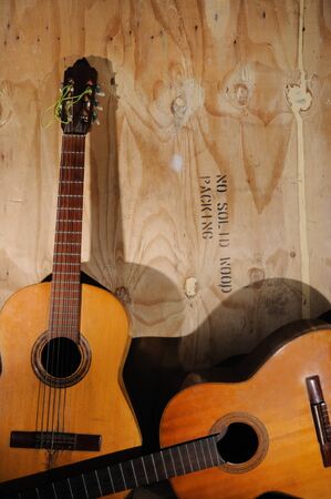 Two Old acoustic guitars against grunge aged surfaceの写真素材