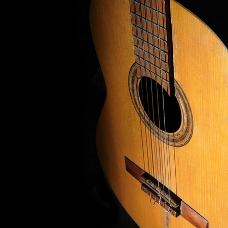 Detail of old acoustic guitar isolated on black