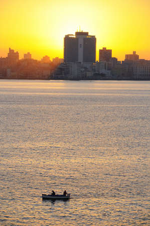 A view of havana skyline at sunset with fishing boat on the frontの写真素材