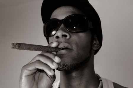 Portrait of young trendy african american man smoking a cigar