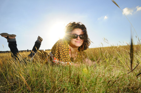Portrait of young fresh beauty relaxing on green grass fieldの写真素材