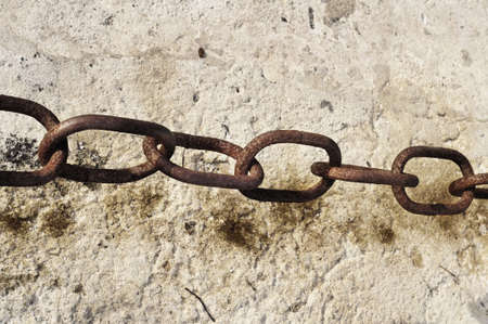 Rusty chain detail over abstract asphalt background の写真素材
