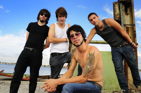 Portrait of young trendy team of male friends posing on grunge urban backgroundの写真素材