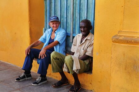 Two senior men sitting in colorful Trinidad street. It was declared by UNESCO World Heritage Site in 1988. Taken circa OCT 2008.のeditorial素材