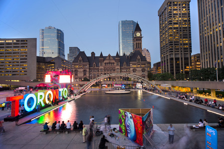 TORONTO,CANADA-JULY 9,2015: Panoramic view of the new Toronto sign in Nathan Phillips Square, host of PanaMania, a contant party celebrating the PanAm games. Old City Hall and downtown buildings in the back.のeditorial素材