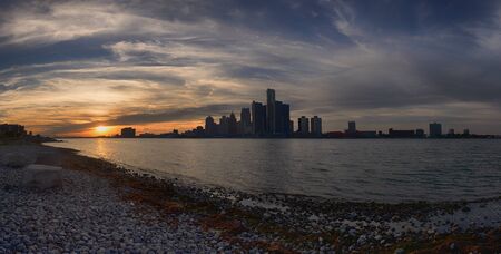 Panoramic view of Detroit skyline from river shoreline at sunsetの写真素材