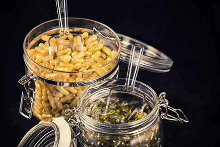 Jars with cannabis extraction capsules infused with shatter and cbd (marijuana compound) isolated over black backgroundの写真素材
