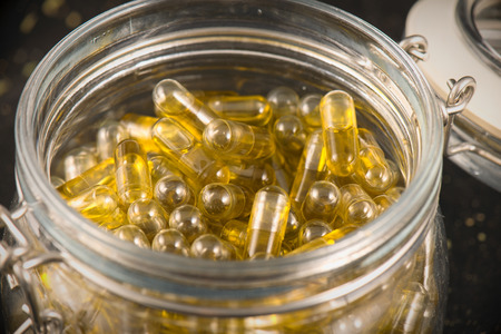 Jar with cannabis extraction capsules infused with shatter and cbd (marijuana compound) - dispensary concept backgroundの写真素材