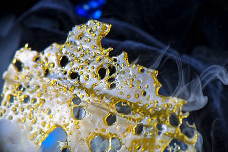 Close up detail of marijuana oil concentrate slab for dabbing aka shatter isolated on black backgroundの写真素材