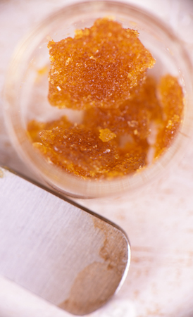 Macro detail of cannabis concentrate live resin (extracted from medical marijuana) isolated over white on a dabbing toolの写真素材