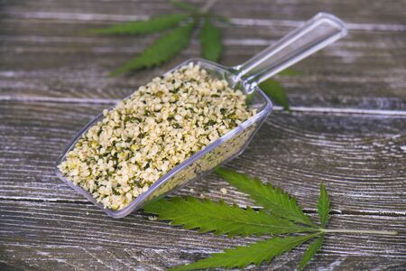 Detail of scooper with a bunch of hulled edible hemp seeds, regarded as a superfood for its nutritional valueの写真素材