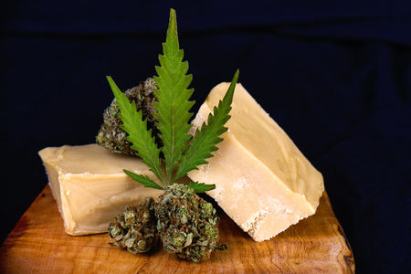 Detail of wood tray with Cannabis infused fudge isolated on black - medical marijuana edibles conceptの写真素材