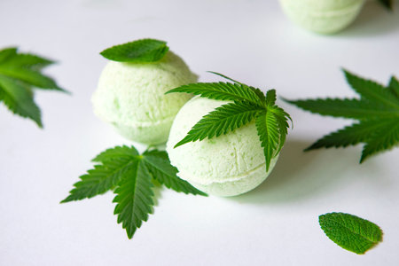 Round green cannabis bath bombs with marijuana leaves isolated on white background