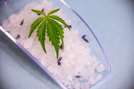 Cannabis infused soaking salts and marijuana leaf - cannabis spa concept