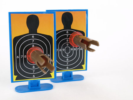 Two target silhouettes with suction cup darts attached to them. Over a white background.の写真素材